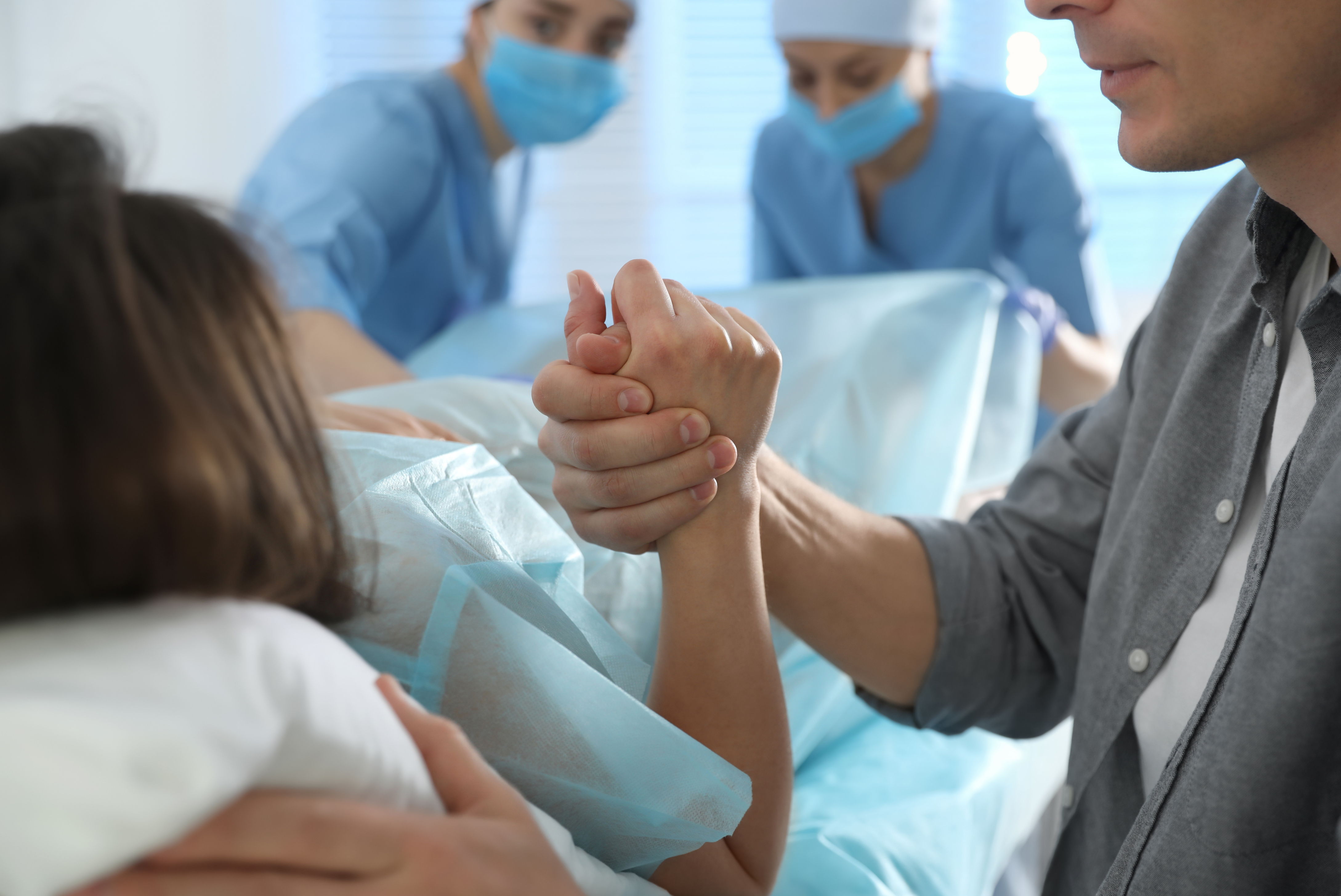 Wife and Husband Holding Hands During Labor